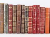 many old books lined up together on a white surface