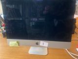 a computer monitor sitting on a desk with a keyboard and mouse