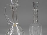 two glass decanters sitting next to each other on a table