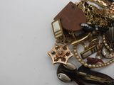 a pile of assorted jewelry on a white surface