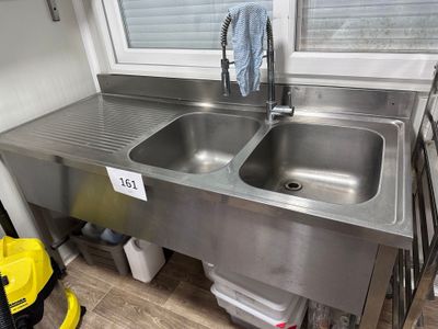 deux éviers en acier inoxydable dans la cuisine, près d'une fenêtre