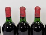 six bottles of wine are lined up in a row on a table