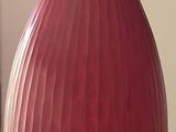 un vase rouge posé sur une table noire dans un salon