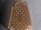 a gold medal hanging from a string on a white surface