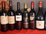 several bottles of wine are lined up on a red table