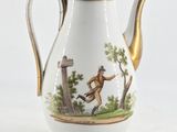 a white and gold coffee pot with a picture of a man on it