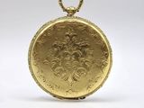 an antique gold pocket watch with a chain on a white background