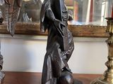 two statues of angels on a table next to a mirror