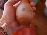 a person holding a glass bottle with a message on it