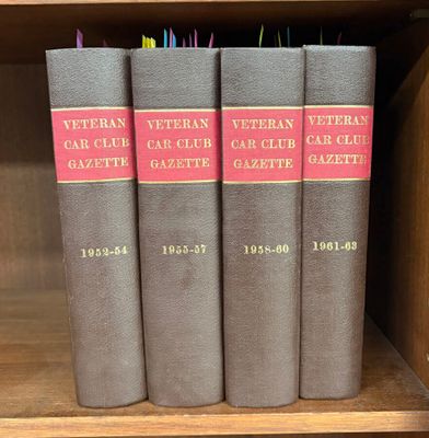 trois livres sur une étagère dans une bibliothèque, dont l'un est rouge et l'autre noir