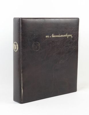 un vieux livre noir orné de lettres dorées, posé sur une surface blanche