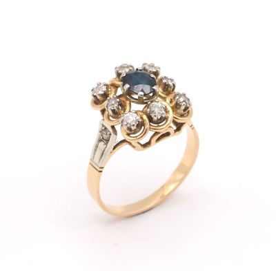 a close up of a gold ring with a sapphire and diamonds