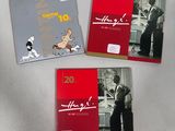 three books on a white table with a dog and a cat
