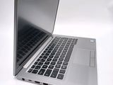 a silver laptop with a black keyboard on a white surface