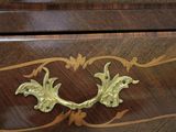 a close up of a wooden dresser with a brass handle