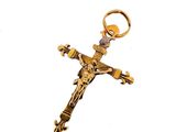 gold plated crucift with a cross on a white background