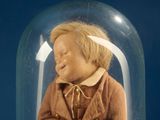 a small doll inside of a glass dome on a table