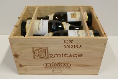 trois bouteilles de vin dans un coffret en bois sur une table