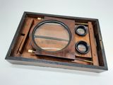 a wooden box with a magnifying glass and a magnifying lens