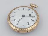 une montre de poche en or avec des chiffres romains sur le cadran
