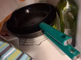 a pan and a bottle on a counter next to a towel