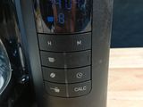 a close up of a coffee maker with a clock on it