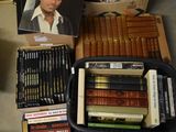 many books on the floor next to a box of cigarettes