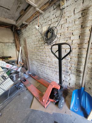 a forklift in a room with a brick wall behind it