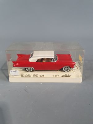 a red toy car with a white top in a clear box