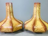 une paire de vases jaunes et marron posés sur une table