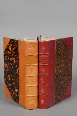 three books are stacked on top of each other on a gray surface