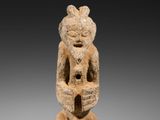 une petite statue d'un homme avec un chapeau sur la tête
