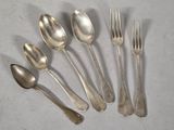 six silver spoons and a fork on a white surface