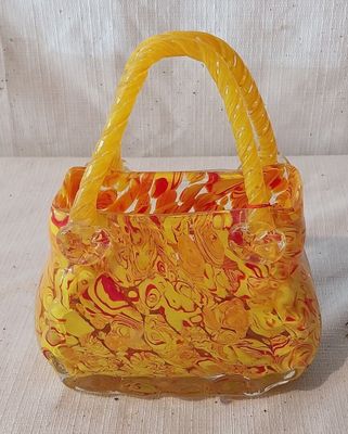 sac à main orange et jaune avec des anses, sur fond blanc