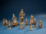 several figurines of people dressed in period clothing and hats