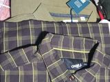 a pile of clothing on a tiled floor next to a laptop