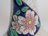 a vase with a flower on it sitting on a table