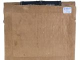 an old cardboard box with a label on it sitting on a white surface