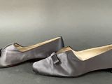 pair of women ' s shoes with bows on the toes on a gray surface