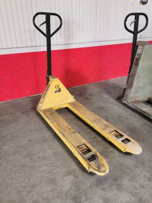 a fork lifter sitting in a warehouse next to another fork lifter