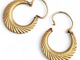 une image représentant une paire de boucles d'oreilles créoles en or sur fond blanc