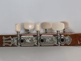 the headstock of a guitar with four white knobs on a white background