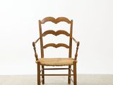 an image of a wooden chair with a woven seat in a room