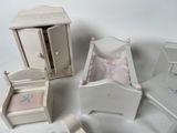 a small doll house with a bed, dresser, chair, and chest
