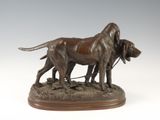 bronze sculpture of two dogs on a leash on a wooden base