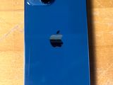 Un iPhone d'Apple est posé sur une table en bois, dans un étui bleu.