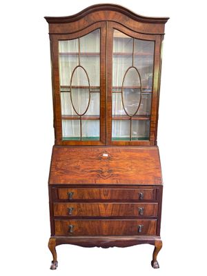 une vieille commode en bois avec des portes vitrées et des tiroirs