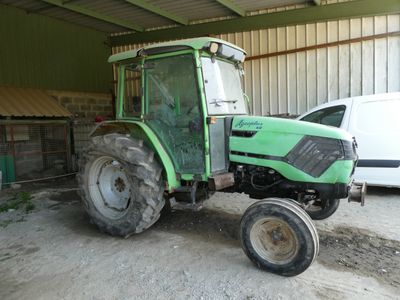 un tracteur vert garé dans un garage