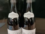 deux bouteilles de vin posées sur une table l'une à côté de l'autre