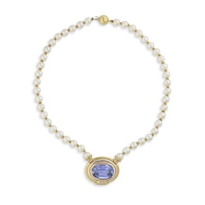 un collier orné d'une pierre bleue et de perles sur fond blanc